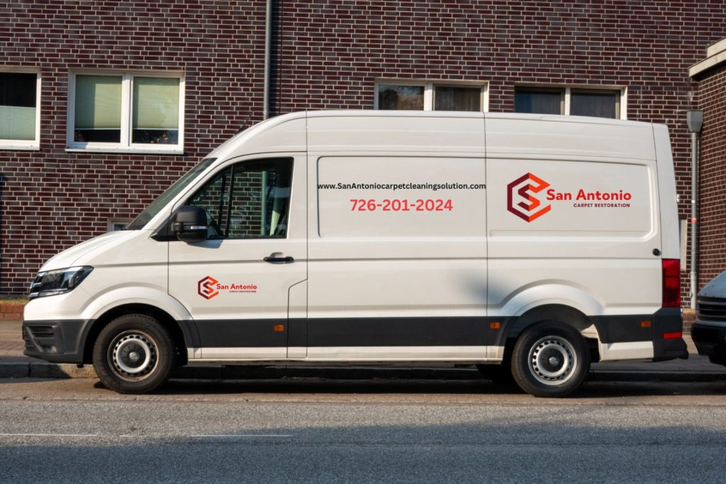 A white van is parked outside a building that houses a carpet and rug cleaning service in San Antonio, TX.