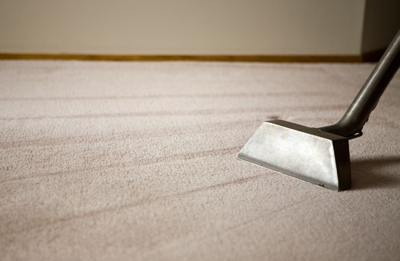 A carpet cleaning machine is actively cleaning a room, representing a carpet restoration service in San Antonio, TX.